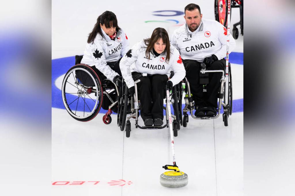 Spallumcheen&rsquo;s Ina Forrest (centre) delivers a rock while Canadian teammates Callinda Joseph (left) and Jon Thurston steady her chair during a preliminary round game at the 2026 Milano Cortina Paralympics in Italy. Canada has secured a spot in the semifinals Friday, March 13. (Angela Burger - Canadian Paralympics Committee)
